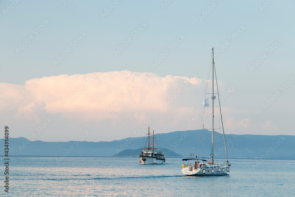Zwei Schiffe auf dem Meer mit Bergen im Hintergrund