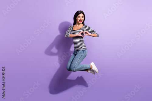 Fototapeta Naklejka Na Ścianę i Meble -  Full size photo of happy smiling cheerful young korean girl jumping showing heart sign isolated on violet color background