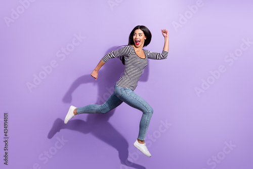 Full size profile side photo of young funky cheerful woman running fast look copyspace isolated on violet color background