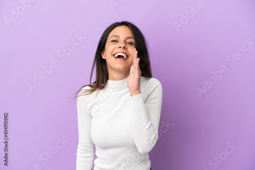 Young caucasian woman isolated on purple background shouting with mouth wide open