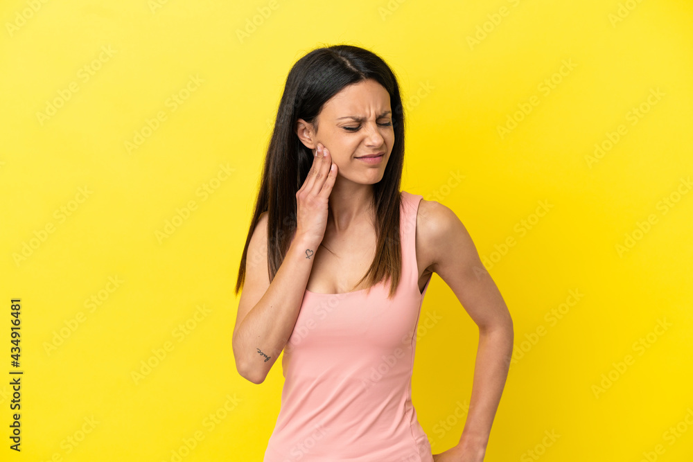 Young caucasian woman isolated on yellow background with toothache Young caucasian woman isolated on yellow background with toothache