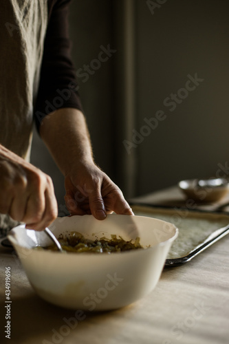 Male hands cooking onion pie filling