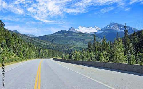 Steep mountain (Mount Albreda) with bright glacier, forests and blue sky above the Southern Yellowhead Highway. British Columbia, Canada.