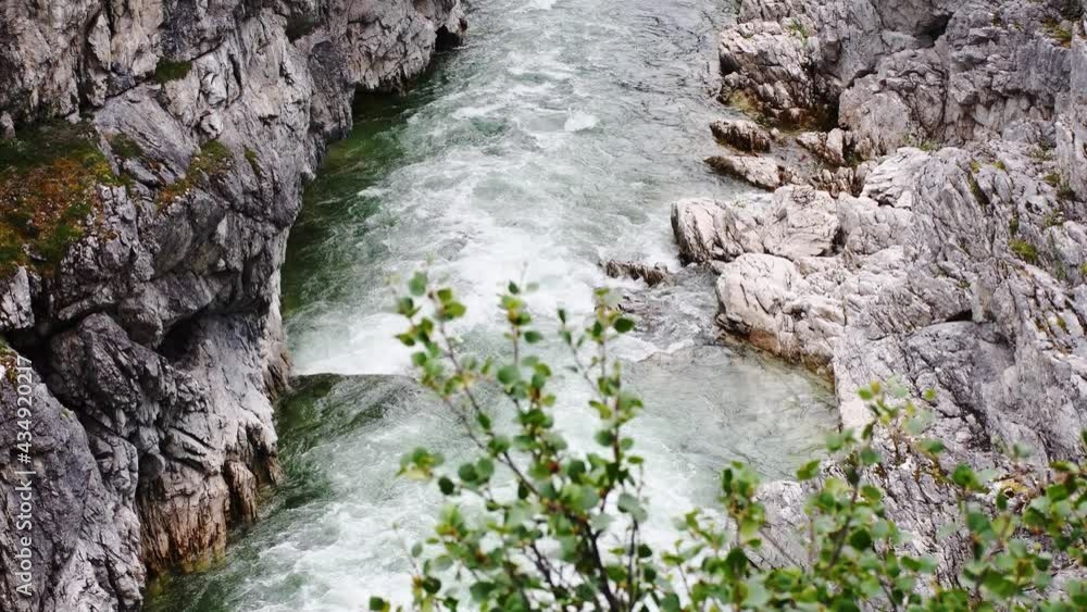 Foamy mountain river with fast moving clear water flowing in rocky canyon Foamy mountain river with fast moving clear water flowing in rocky canyon