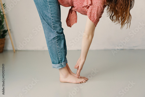Supple young woman bending down to touch her toes