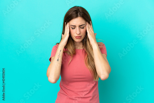 Young caucasian woman isolated on blue background with headache