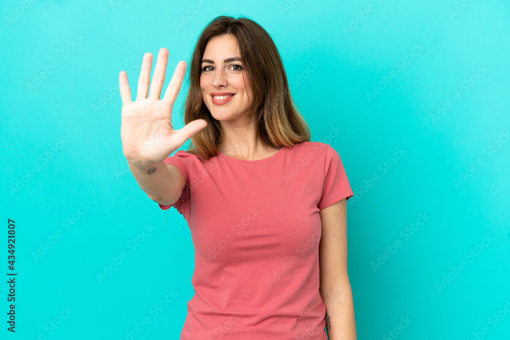 Fototapeta premium Young caucasian woman isolated on blue background counting five with fingers