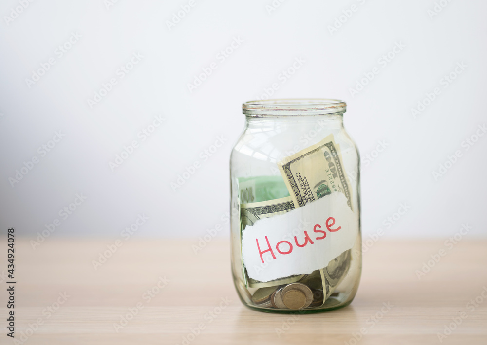 Glass jar with money with the inscription - house. Glass jar with money with the inscription - house.