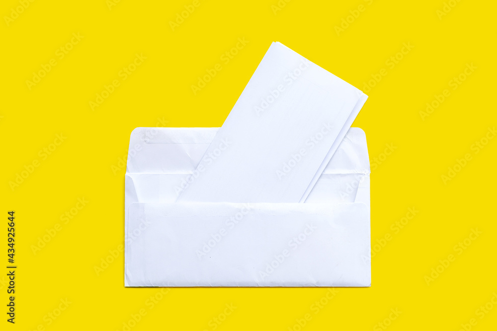 Open white envelope with paper on yellow background. Open white envelope with paper on yellow background.