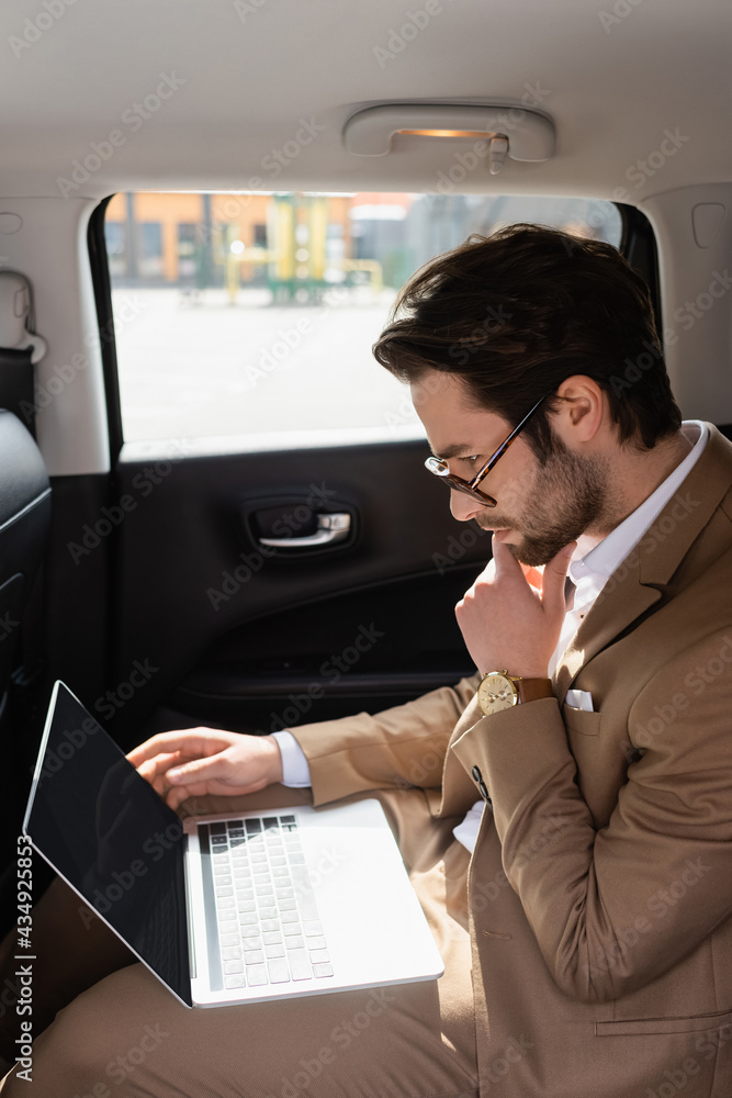 pensive businessman in glasses working remotely in car