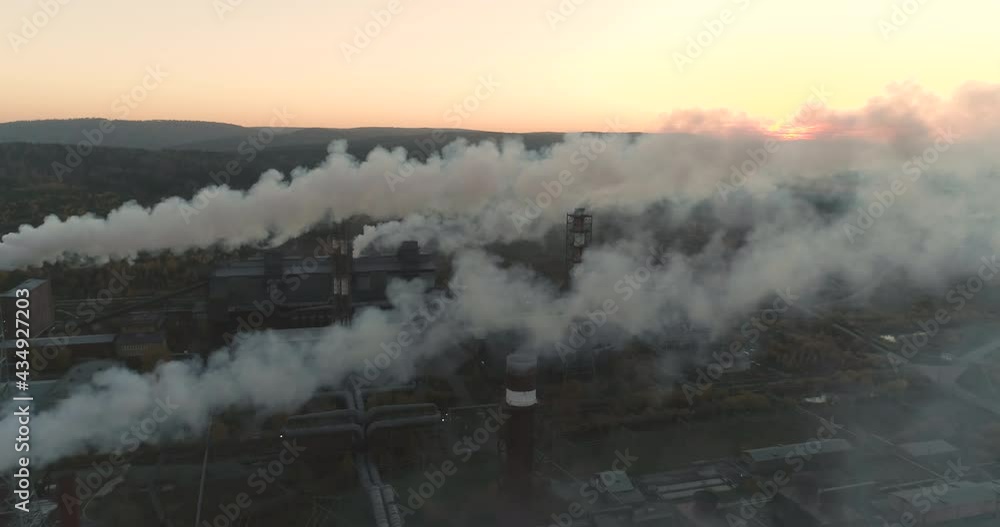 Aerial View. Emission to the Atmosphere from Industrial Pipes. Smokestack Chimneys. Industrial Background of Metallurgical Production Factory Steel factory at sunset. Aerial View. Emission to the Atmosphere from Industrial Pipes. Smokestack Chimneys. Industrial Background of Metallurgical Production Factory Steel factory at sunset.