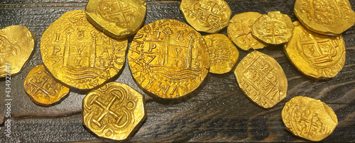 shiny gold coins on dark wooden background © Tamela