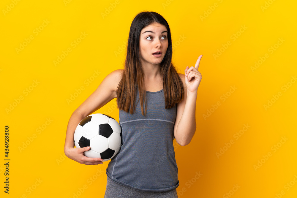 Young football player woman isolated on yellow background thinking an idea pointing the finger up Young football player woman isolated on yellow background thinking an idea pointing the finger up
