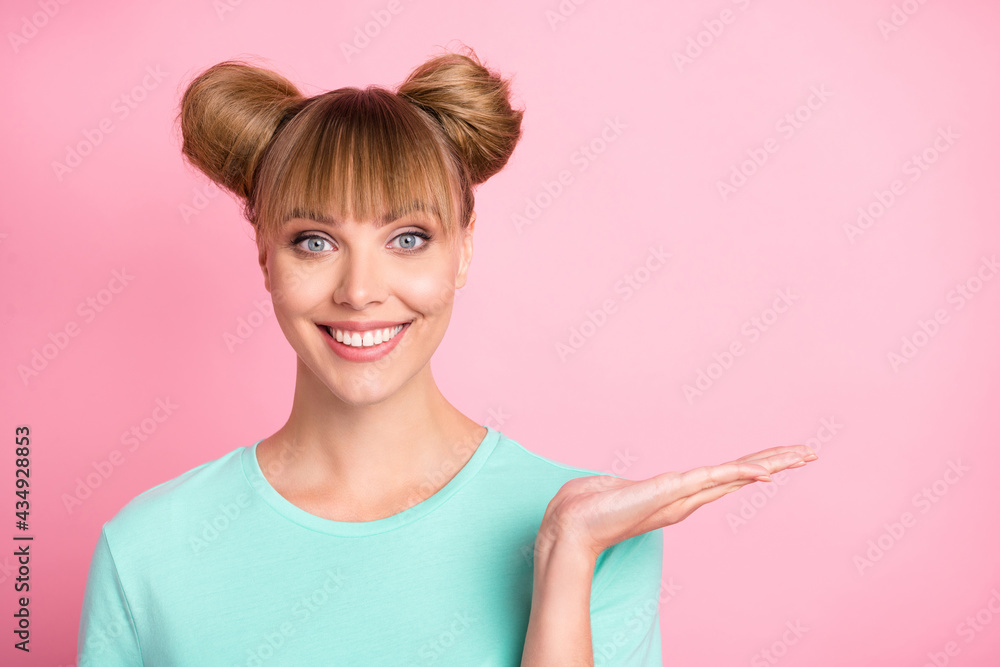 Portrait of adorable person toothy smile arm hold showing product good mood isolated on pink color background Portrait of adorable person toothy smile arm hold showing product good mood isolated on pink color background