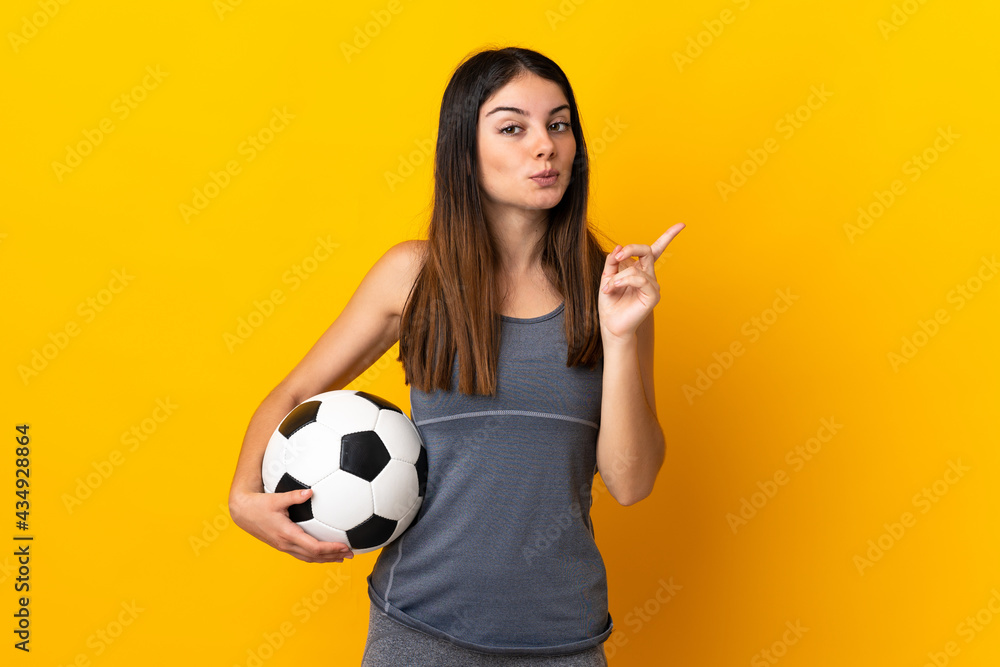 Young football player woman isolated on yellow background intending to realizes the solution while lifting a finger up Young football player woman isolated on yellow background intending to realizes the solution while lifting a finger up