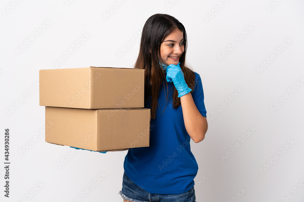 Young delivery woman protecting from the coronavirus with a mask isolated on white background thinking an idea and looking side Young delivery woman protecting from the coronavirus with a mask isolated on white background thinking an idea and looking side