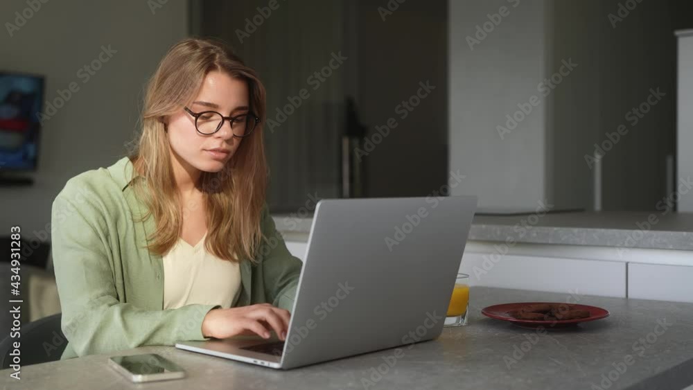 The concentrated woman typing something on the laptop while sitting in the room The concentrated woman typing something on the laptop while sitting in the room