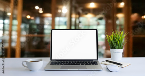 Front view of open laptop computer notebook with blank monitor white screen display on work table desk. Workspace office modern for job business online communication technology in shop or home indoor.