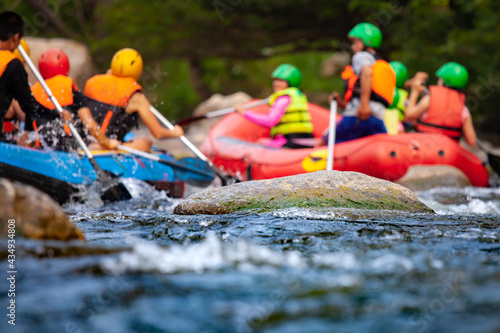 Close-up of reef with group of young people are rafting on the river, at tourist attraction.