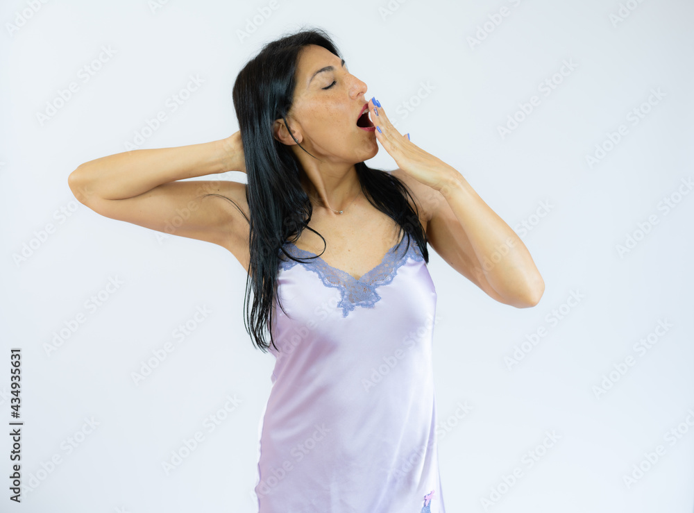 Smiling woman in nightgown yawning isolated over white background. Smiling woman in nightgown yawning isolated over white background.