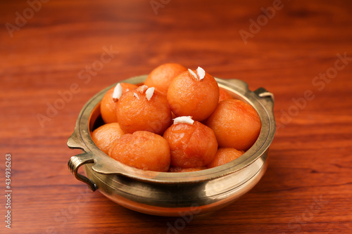 Gulab jamun , gulaab jamun in sugar syrup golden bowl Indian sweet food mithai Egyptian Zalabia balls dessert fried delicacy in honey Pakistan, India, Sri Lanka, Kerala, Arab on Ramadan Diwali 