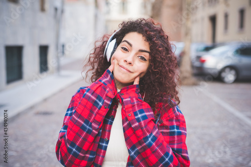 Portrait young multiethnic woman outdoors listening music smiling © Eugenio Marongiu