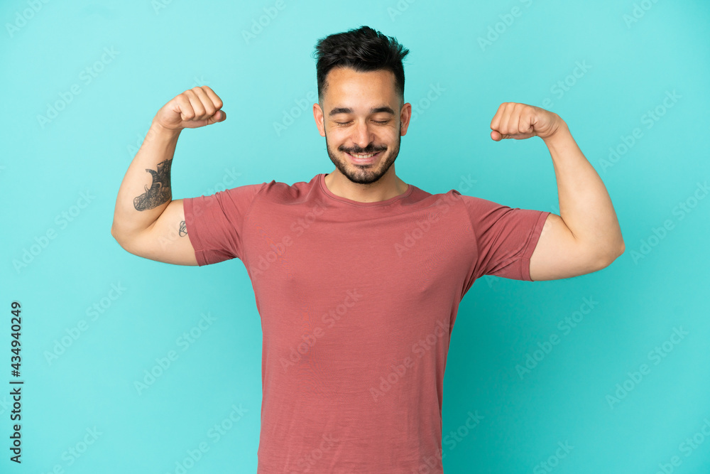 Young caucasian man isolated on blue background doing strong gesture Young caucasian man isolated on blue background doing strong gesture