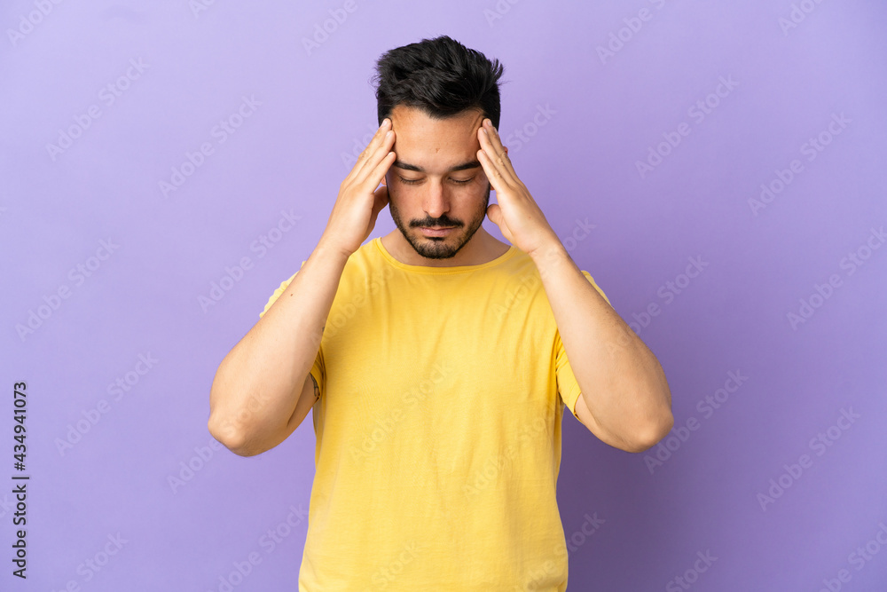 Young caucasian man isolated on purple background with headache Young caucasian man isolated on purple background with headache