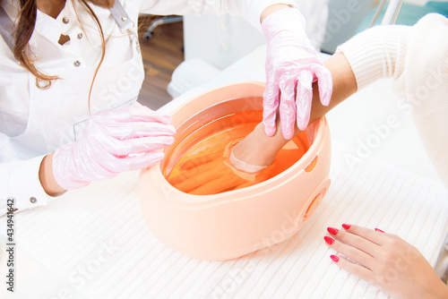 Fotografia process paraffin treatment of female hands in beauty salon