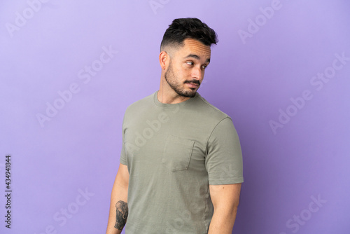 Young caucasian man isolated on purple background . Portrait