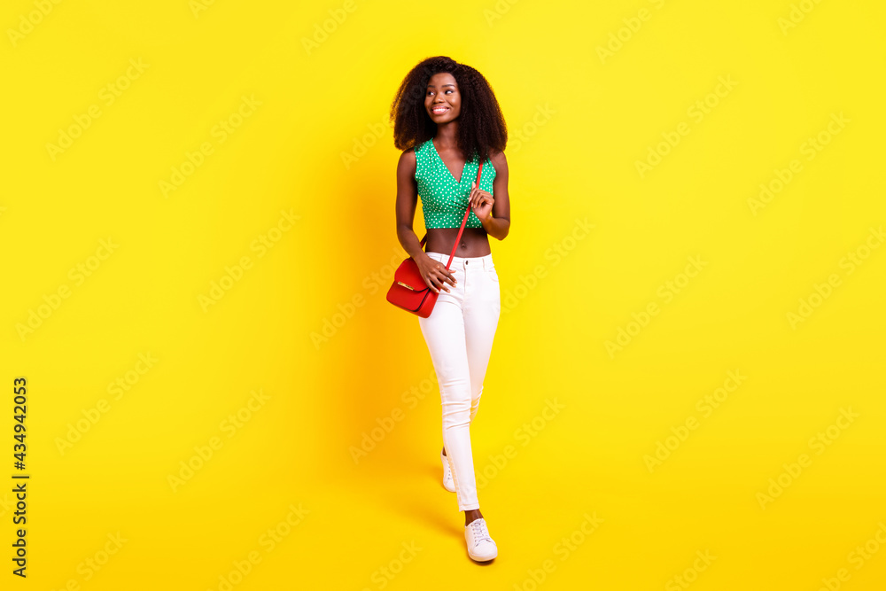 Full length body size photo woman in stylish clothes going forward smiling looking blank space isolated vibrant yellow color background Full length body size photo woman in stylish clothes going forward smiling looking blank space isolated vibrant yellow color background