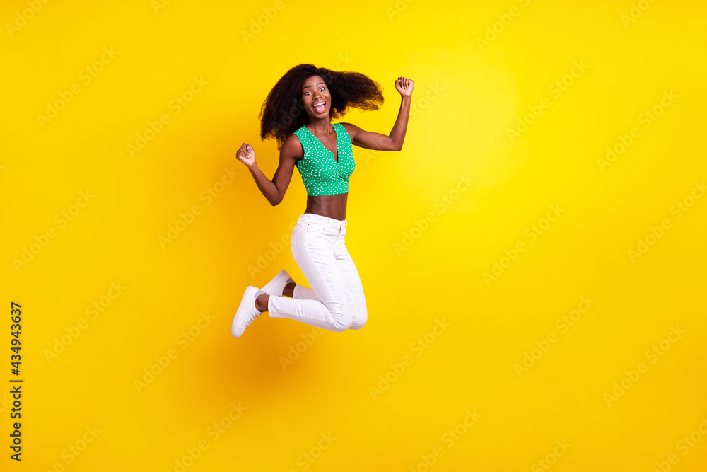 Full length body size photo young girl jumping gesturing like winner isolated vibrant yellow color background