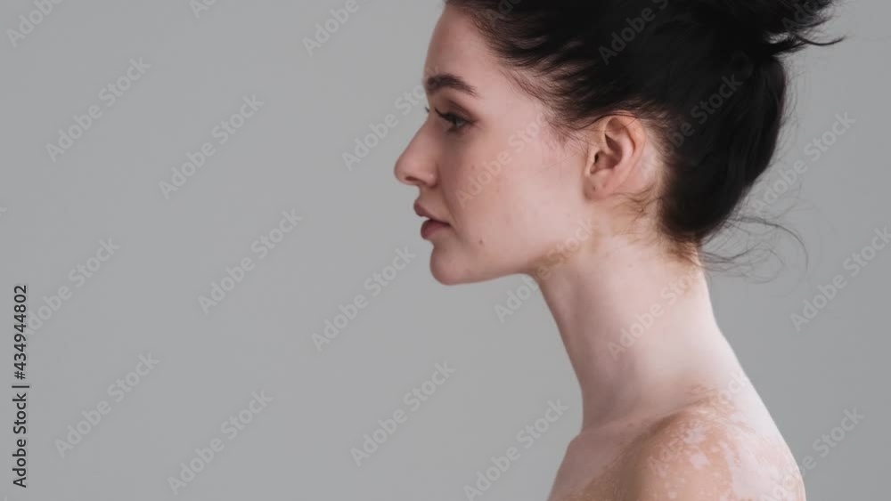 A beautiful half naked woman is turning her head to the camera standing isolated over gray wall in the studio. Diversity tolerance. Every body is beautiful A beautiful half naked woman is turning her head to the camera standing isolated over gray wall in the studio. Diversity tolerance. Every body is beautiful
