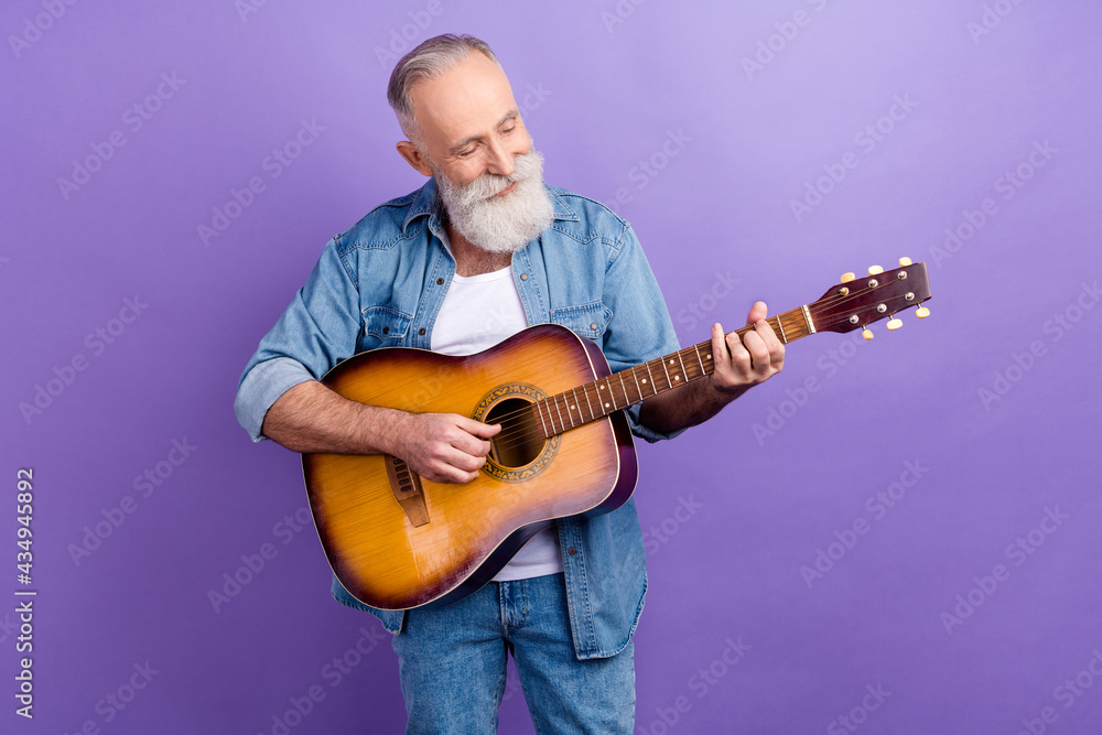 Obraz premium Photo of elderly handsome man happy positive smile play guitar concert isolated over purple color background