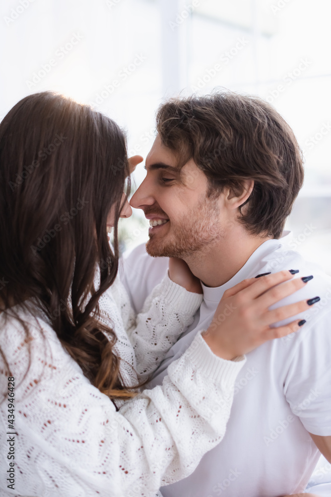 Smiling man looking at girlfriend in sweater at home Smiling man looking at girlfriend in sweater at home