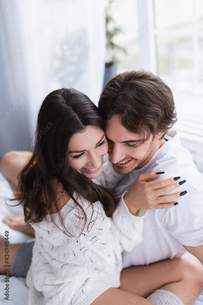 Smiling young couple hugging in bedroom Smiling young couple hugging in bedroom