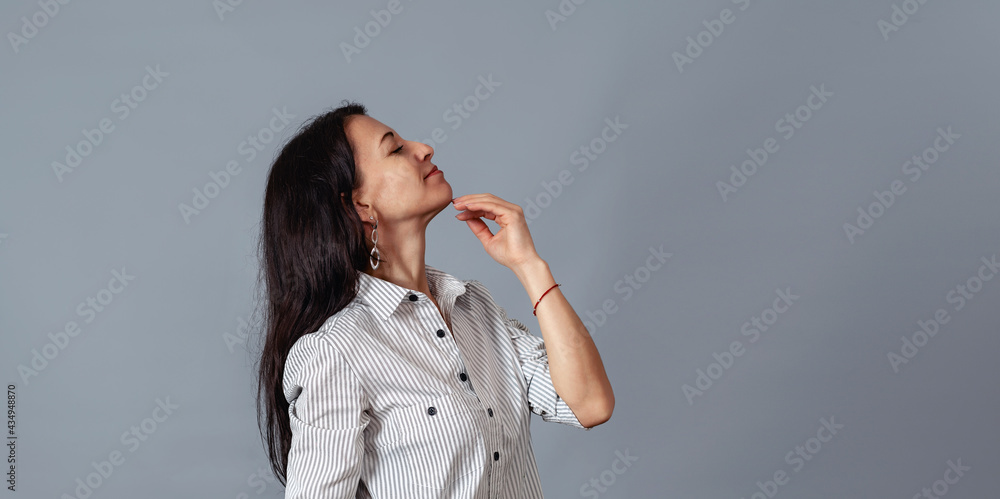 middle-aged woman holds her hand near her chin middle-aged woman holds her hand near her chin
