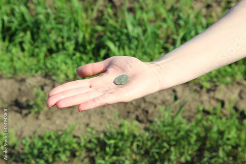 Woman's hand holding an old coin © Alex Milan