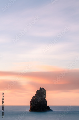 Sea stack in sea at sunrise