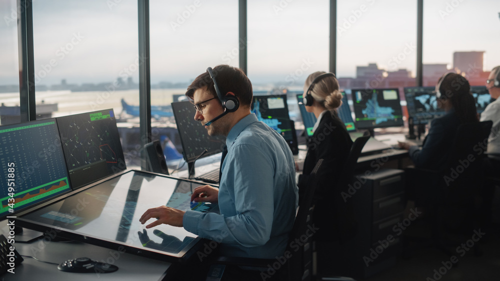 Diverse Air Traffic Control Team Working in a Modern Airport Tower. Office Room is Full of Desktop Computer Displays with Navigation Screens, Airplane Departure and Arrival Data for Controllers. - obrazy, fototapety, plakaty 