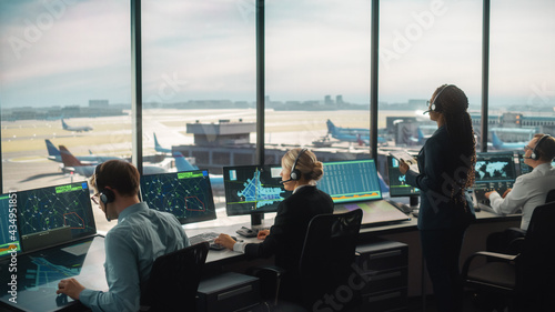 Diverse Air Traffic Control Team Working in a Modern Airport Tower. Office Room is Full of Desktop Computer Displays with Navigation Screens, Airplane Departure and Arrival Data for Controllers. photo