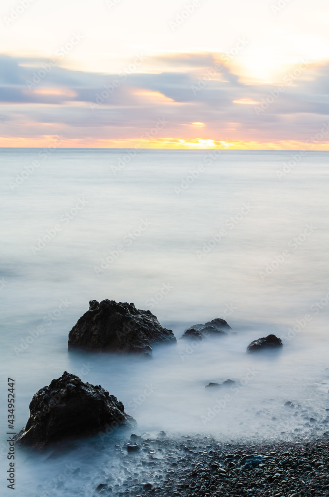 Fototapeta premium Rock formations in sea at sunset