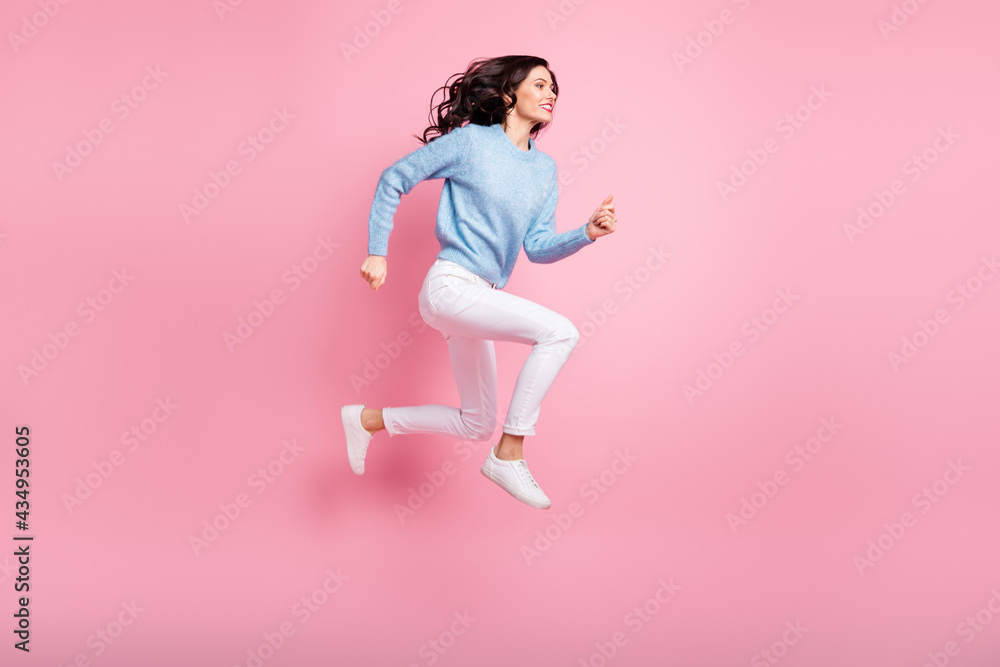 Full length profile photo of funny girl jump run fast wear blue pullover isolated pink color background