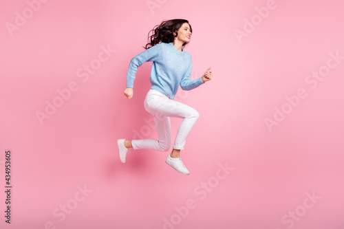 Fototapeta Naklejka Na Ścianę i Meble -  Full length profile photo of funny girl jump run fast wear blue pullover isolated pink color background