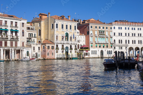 facades facing blue clean waters of busy grand canal of Venice