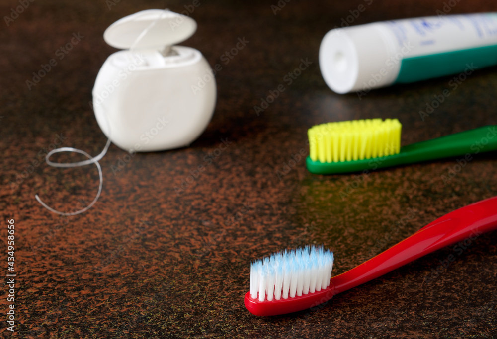 Oral hygiene items with dark background close up, toothbrushes, dental floss Oral hygiene items with dark background close up, toothbrushes, dental floss