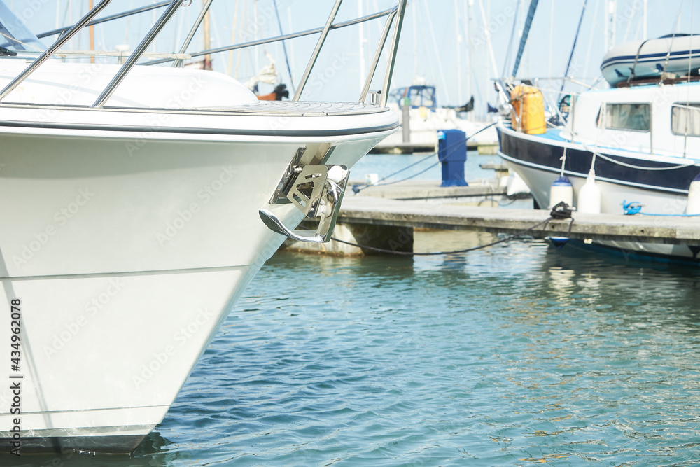 Fototapeta premium Yacht anchor close-up seen on the front of a large boat. Sailboat bow parked in harbor, yachting, sailing