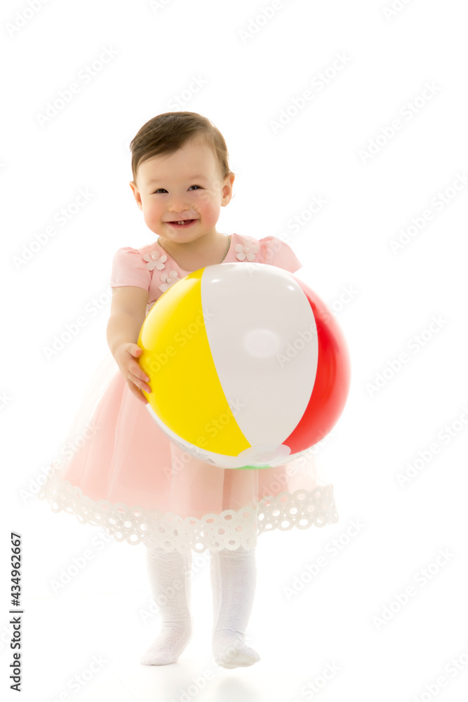Little girl is playing with a ball.The concept of children's sports, summer outdoor recreation. Little girl is playing with a ball.The concept of children's sports, summer outdoor recreation.