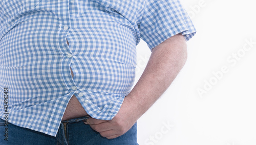Overweight man trying to fasten too small clothes isolated on white background: Selective focus. photo