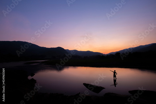 The view of the mountain river, the evening sky, there is a man standing in the water shadow The scenery in the evening gives a feeling of loneliness in Thailand.